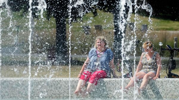 La gente se refresca descansando junto a fuentes cuando hace calor en Varsovia, Polonia - Sputnik Mundo