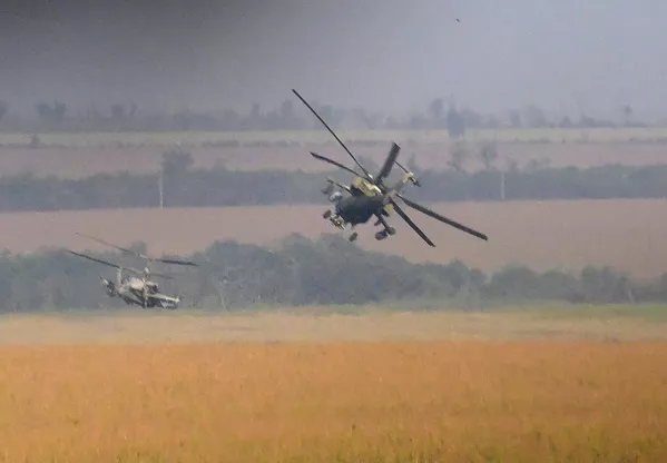 En esta imagen se ve un helicóptero de reconocimiento y ataque Ka-52 Alligator escoltado por un helicóptero polivalente Mi-8 que transporta un equipo de apoyo de fuego y rescate. - Sputnik Mundo