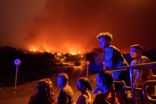 Personas esperan acceder a sus casas en el pueblo de Benijo, en la isla de Tenerife, bloqueadas por la Policía tras los incendios forestales. Personas esperan acceder a sus casas en el pueblo de Benijo, en la isla de Tenerife, bloqueadas por la Policía tras los incendios forestales. - Sputnik Mundo