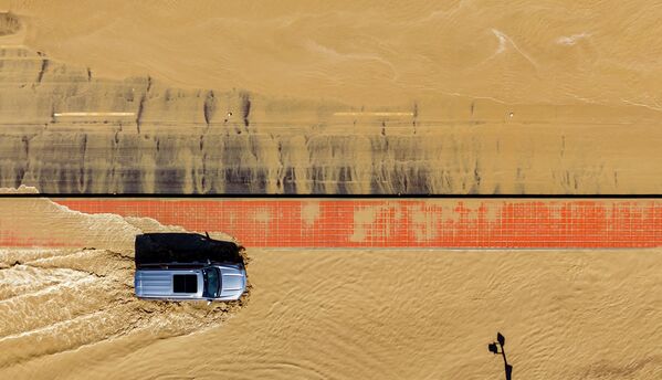 Un coche circula por una carretera inundada en Thousand Palms, California, Estados Unidos, tras el paso de la tormenta tropical Hilary. Un coche circula por una carretera inundada en Thousand Palms, California, Estados Unidos, tras el paso de la tormenta tropical Hilary. - Sputnik Mundo