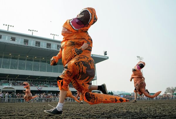 Participantes en el Campeonato Mundial de Carreras de T-Rex con disfraces hinchables en el estadio Emerald Downs de Auburn, EEUU. Participantes en el Campeonato Mundial de Carreras de T-Rex con disfraces hinchables en el estadio Emerald Downs de Auburn, EEUU. - Sputnik Mundo