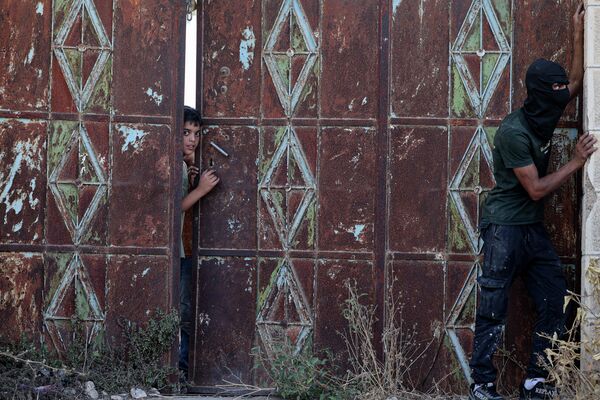 Adolescentes palestinos se esconden durante una operación de registro del Ejército israelí tras los enfrentamientos palestino-israelíes en la aldea de Baita, en Cisjordania, ocupada por Israel. Adolescentes palestinos se esconden durante una operación de registro del Ejército israelí tras los enfrentamientos palestino-israelíes en la aldea de Baita, en Cisjordania, ocupada por Israel. - Sputnik Mundo