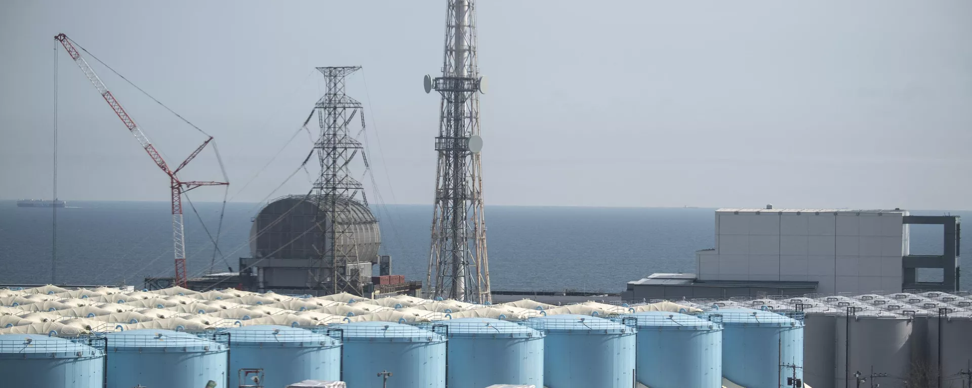 Los reactores de las unidades 3 (L) y 4 (C) y los tanques de almacenamiento de agua contaminada en la central nuclear Fukushima en Okuma Los reactores de las unidades 3 (L) y 4 (C) y los tanques de almacenamiento de agua contaminada en la central nuclear Fukushima en Okuma - Sputnik Mundo, 1920, 26.08.2023