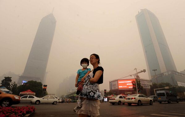 Por desgracia, el progreso tecnológico tiene un inconveniente — la alteración del equilibrio ecológico del planeta.En la foto: una mujer con un niño en Wuhan, provincia china de Hubei. - Sputnik Mundo