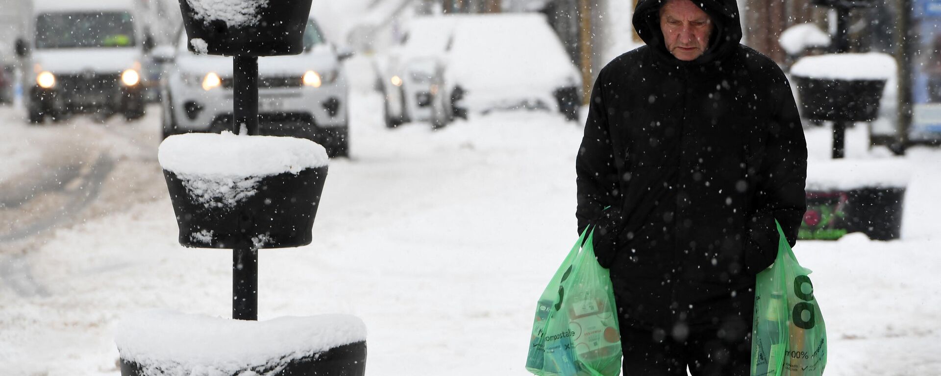 Un hombre lleva sus compras a través de la nieve en Escocia, el 18 de febrero de 2022 - Sputnik Mundo, 1920, 29.09.2023