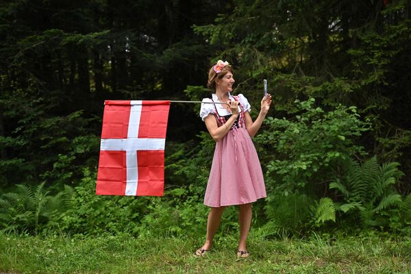 Una espectadora con un traje tradicional y la bandera nacional danesa en la ruta de la carrera durante la 14.ª etapa de la 110.ª edición del Tour de Francia de ciclismo, 152 km entre Annemasse y Morzine Les Portes du Soleil, en los Alpes franceses. 15 de julio de 2023. - Sputnik Mundo