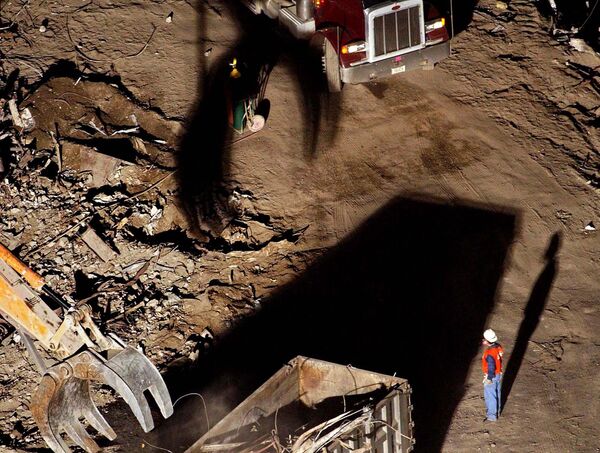 Un trabajador observa cómo una grúa traslada escombros a un camión en los restos del complejo del World Trade Center en Nueva York, el 5 de octubre de 2001. Los trabajadores seguían retirando los escombros de las torres del World Trade Center, tras ser destruidas por dos aviones en un atentado terrorista.  - Sputnik Mundo