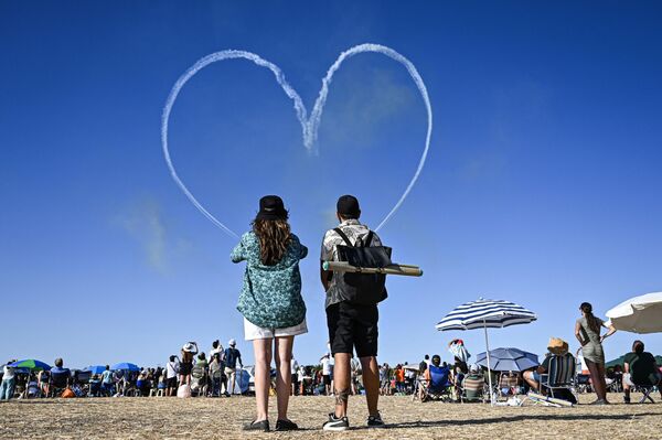 Espectadores observan la actuación del equipo de vuelo acrobático de élite emiratí Fursan Al Emarati, de la Fuerza Aérea de Emiratos Árabes Unidos. - Sputnik Mundo