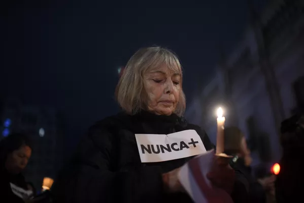 Una mujer sostiene una vela encendida y un cartel en el que se lee "Nunca más" mientras participa en una marcha de mujeres alrededor del Palacio de la Moneda. Una mujer sostiene una vela encendida y un cartel en el que se lee "Nunca más" mientras participa en una marcha de mujeres alrededor del Palacio de la Moneda. - Sputnik Mundo