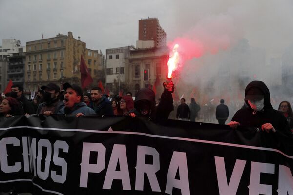 Un manifestante enciende una bengala durante una marcha para conmemorativa al 50 aniversario del golpe militar. - Sputnik Mundo