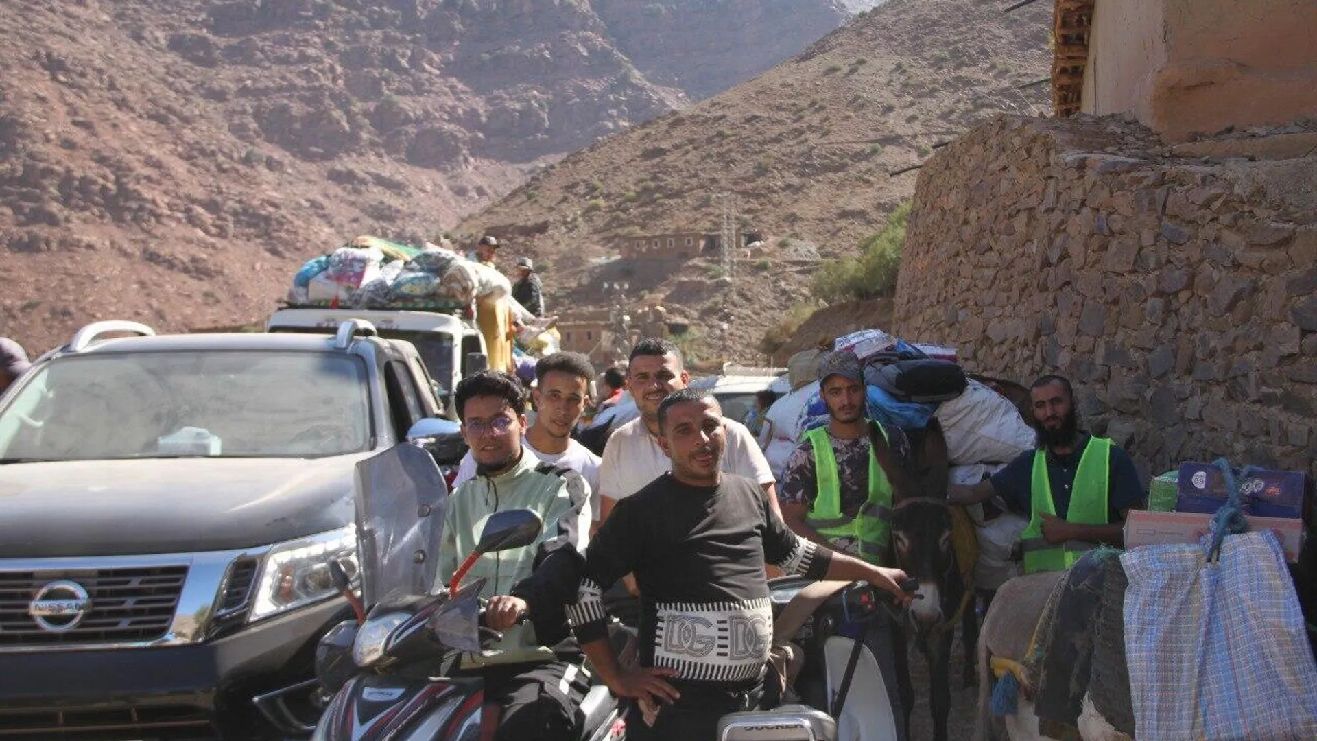 Adultos y niños participan en el reparto de ayuda en las montañas afectadas por el terremoto de Marruecos, 15 de septiembre de 2023