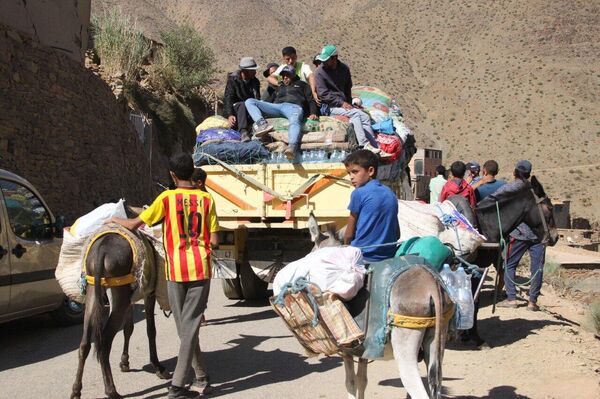 Adultos y niños participan en el reparto de ayuda en las montañas afectadas por el terremoto de Marruecos, 15 de septiembre de 2023 - Sputnik Mundo