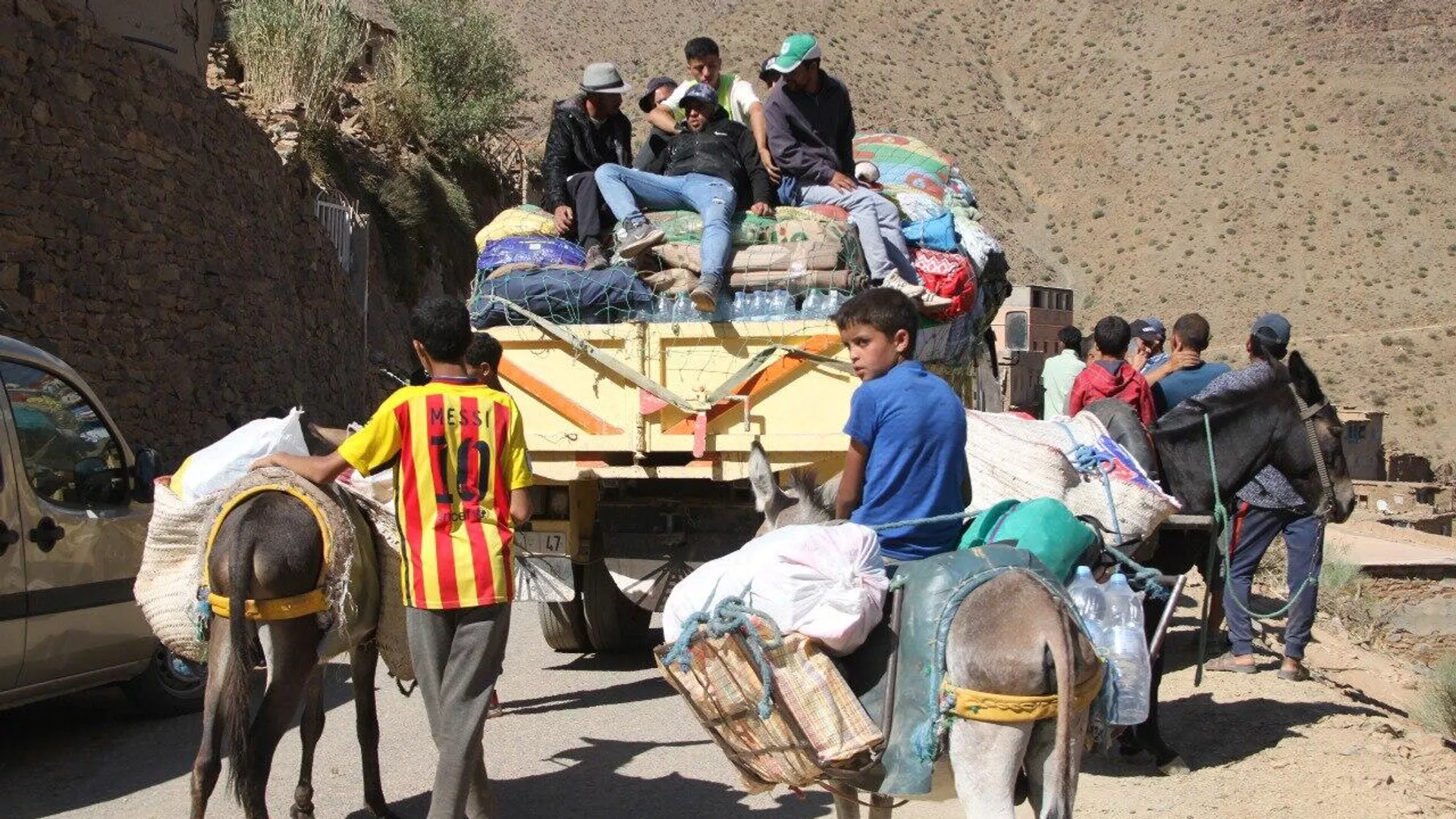 Adultos y niños participan en el reparto de ayuda en las montañas afectadas por el terremoto de Marruecos, 15 de septiembre de 2023