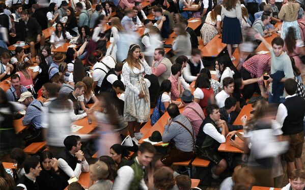 El Oktoberfest en otros países dura generalmente una semana y también tiene el objetivo de estimular la dinámica comercial.En la foto: visitantes se sientan en sus lugares en una carpa de cerveza. - Sputnik Mundo