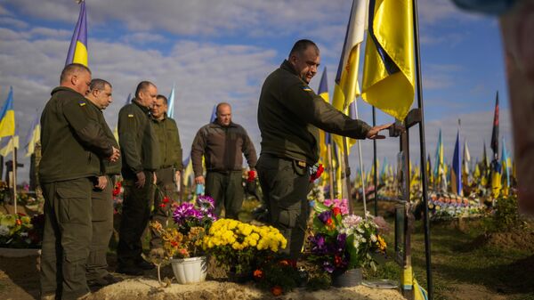 Militares ucranianos depositan flores en la tumba de un compañero soldado recientemente asesinado en un cementerio Járkov, Ucrania - Sputnik Mundo