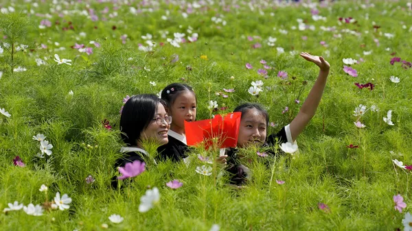 Una mujer y dos niñas en un campo de flores el Día Nacional del Campo en Hangzhou, China. - Sputnik Mundo