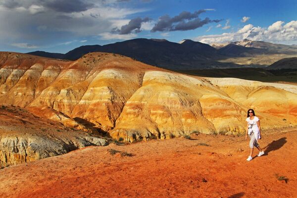 En segundo lugar, están los montes Altái, también uno de los más antiguos del planeta. El 35% de los participantes votaron por ellos. Se cree que el nombre de las montañas proviene de la palabra mongola altan, que significa dorado.En la foto: una mujer en la estepa de la República de Altái. El alto contenido de mercurio en la roca le otorga un color rojizo. - Sputnik Mundo