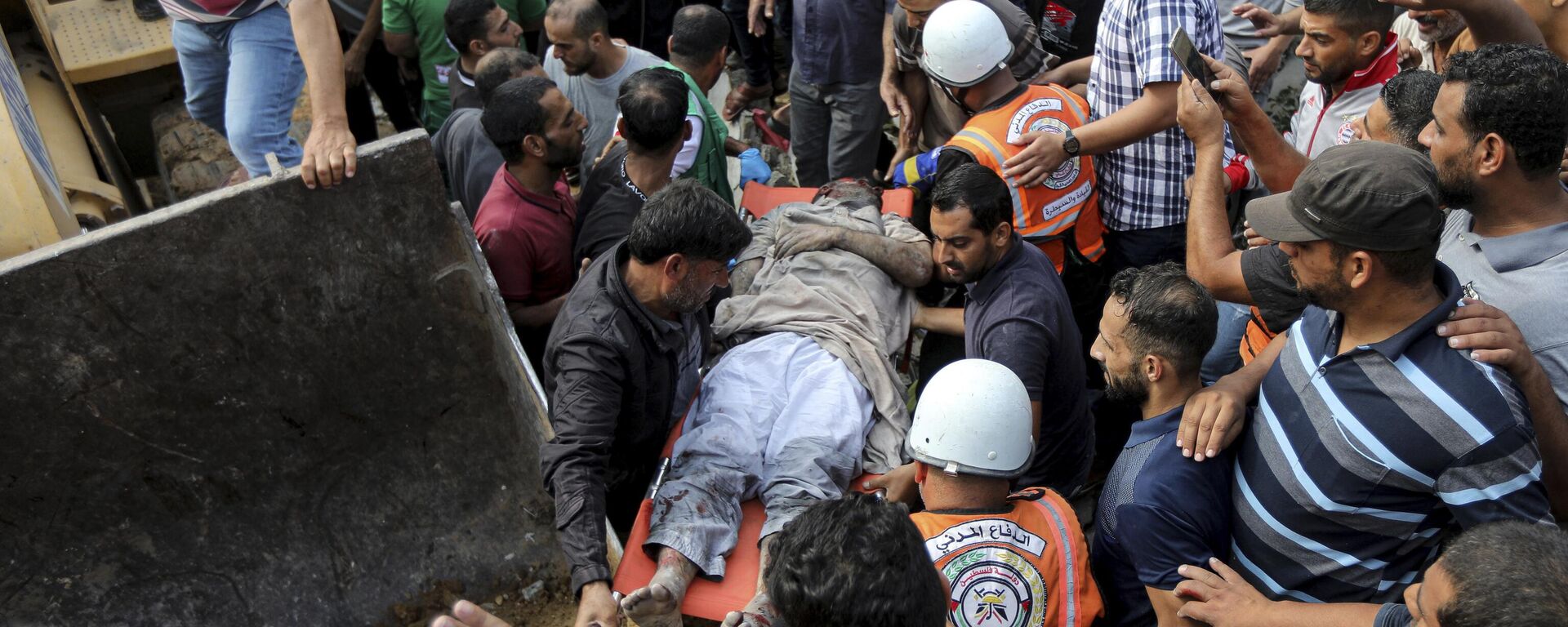Palestinos trasladando a una víctima de los bombardeos israelíes en la Franja de Gaza - Sputnik Mundo, 1920, 14.10.2023
