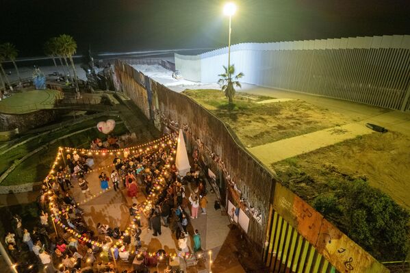 Vista aérea de músicos y bailarines actuando en el 15.º Fandango Fronterizo en Playas de Tijuana, Baja California, México, en la frontera con EEUU. Antes del refuerzo de la seguridad por parte de los estadounidenses, este tipo de actuaciones se celebraban a ambos lados de la frontera. - Sputnik Mundo