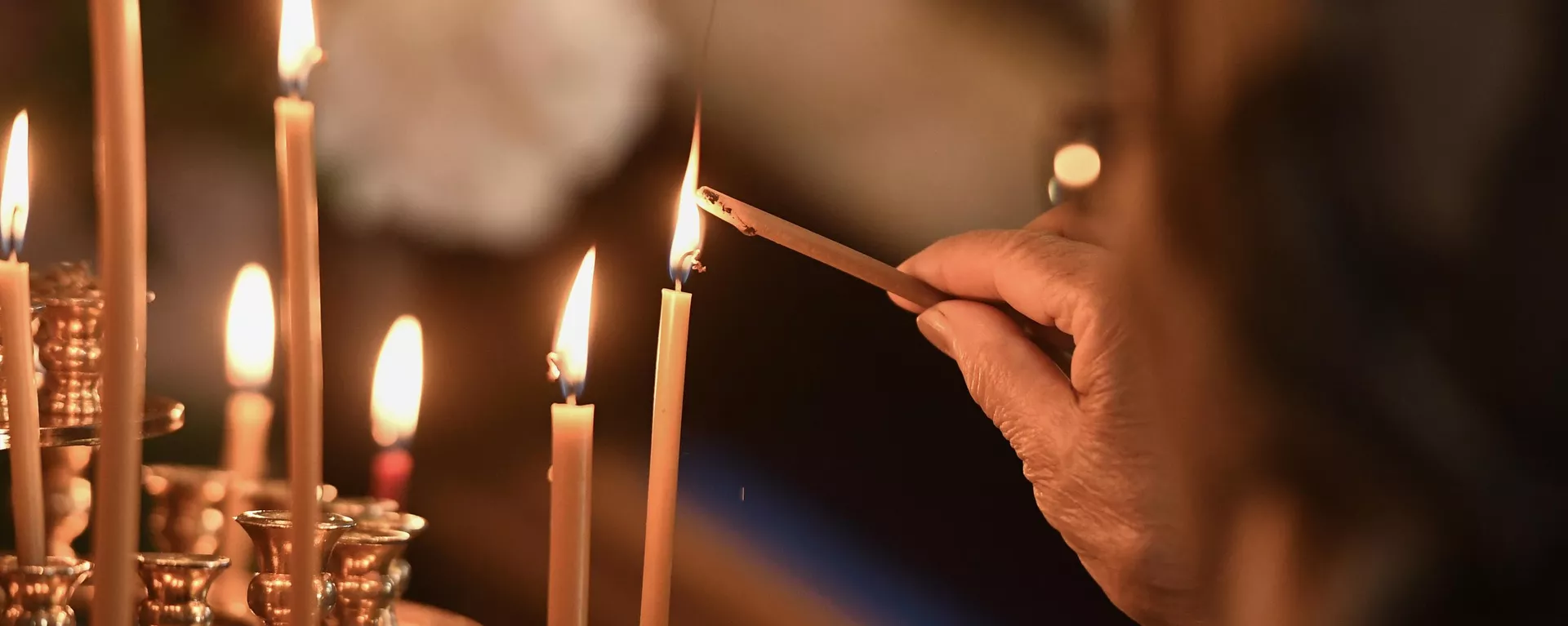 Una mujer coloca una vela de la iglesia durante la Divina Liturgia - Sputnik Mundo, 1920, 20.10.2023