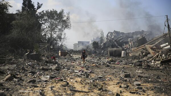 Un niño palestino camina junto a los edificios destruidos en el bombardeo israelí sobre al-Zahra - Sputnik Mundo