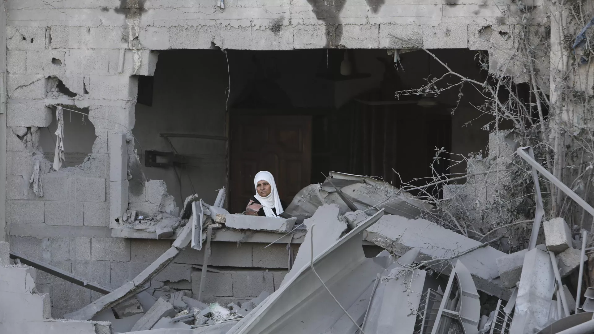 Una mujer palestina mira por la ventana tras un ataque israelí contra la Franja de Gaza en Rafah, el 21 de octubre