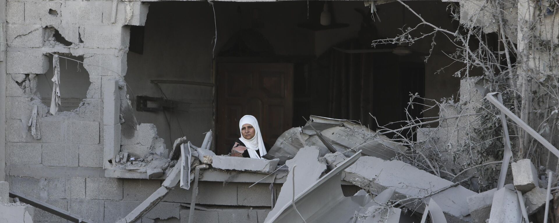 Una mujer palestina mira por la ventana tras un ataque israelí contra la Franja de Gaza en Rafah, el 21 de octubre - Sputnik Mundo, 1920, 21.10.2023