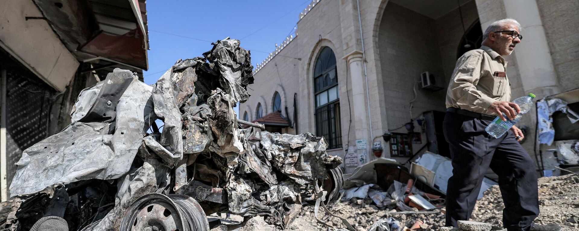 Una persona camina entre escombros afuera de una mezquita en Cisjordania, en la ciudad de Yenín (imagen referencial). - Sputnik Mundo, 1920, 22.10.2023