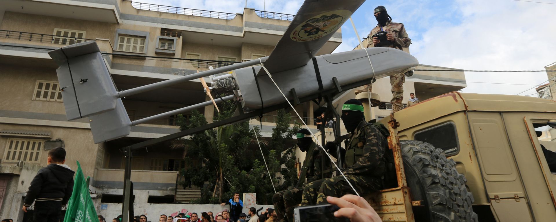 Militantes palestinos de las Brigadas Ezzedine al-Qassam, el brazo armado de Hamás, desembarcan un dron durante un desfile con motivo del 27 aniversario de la creación del movimiento islamista, el 14 de diciembre de 2014 en la ciudad de Gaza. Militantes palestinos de las Brigadas Ezzedine al-Qassam, el brazo armado de Hamás, desembarcan un dron durante un desfile con motivo del 27 aniversario de la creación del movimiento islamista, el 14 de diciembre de 2014 en la ciudad de Gaza. - Sputnik Mundo, 1920, 26.10.2023