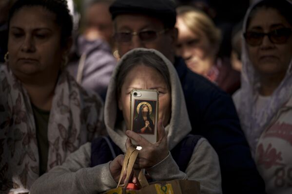 Una mujer de Rumanía hace fotos de una procesión religiosa el día de la conmemoración de San Demetrio Basarabov, patrón de la capital rumana. - Sputnik Mundo