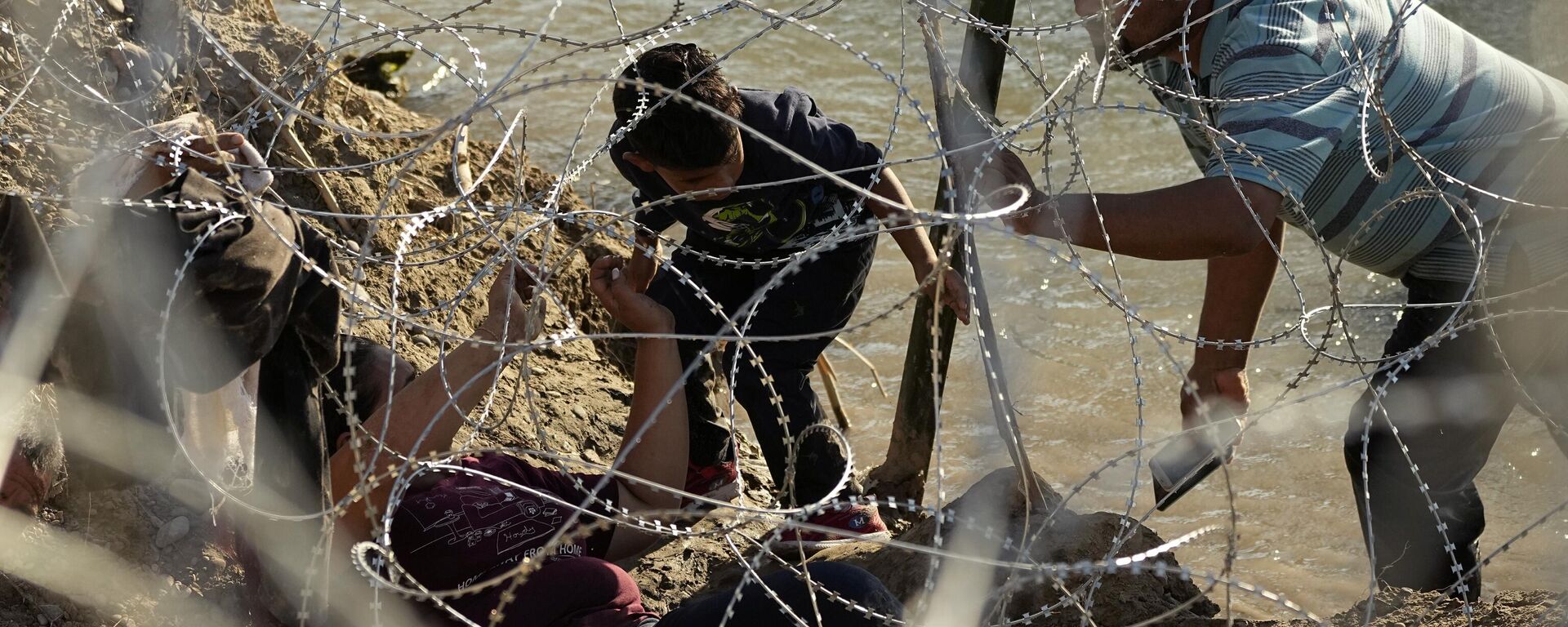 Migrantes tratando de cruzar la frontera entre México y Estados Unidos  - Sputnik Mundo, 1920, 25.12.2023