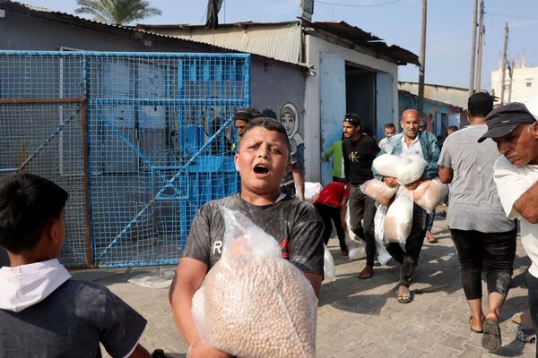 La operación terrestre de las Fuerzas de Defensa de Israel (FDI) aisló completamente del mundo a la Franja de Gaza. Israel derribó todas las torres de comunicación, dejando el enclave sin Internet durante 36 horas.En la foto: un adolescente palestino con una bolsa de garbanzos recibida en un centro humanitario de la ONU. - Sputnik Mundo