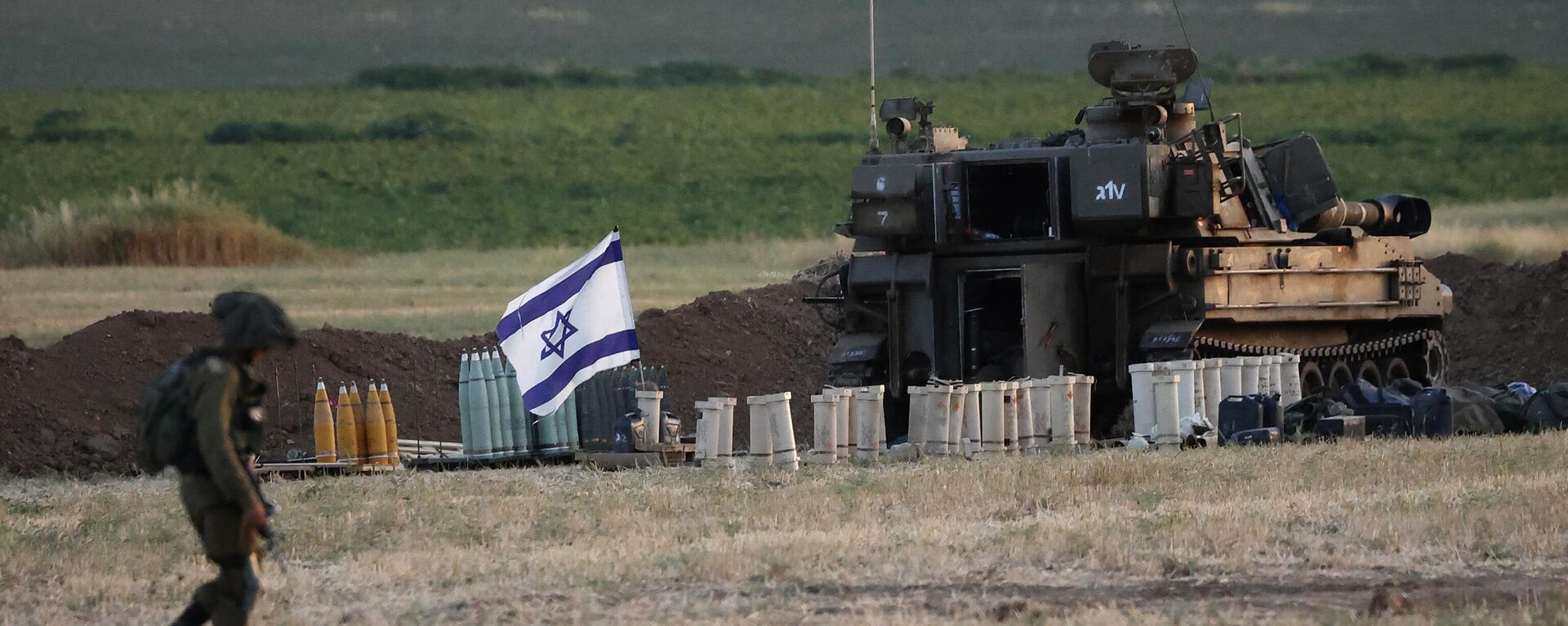 Un soldado israelí camina junto a un obús autopropulsado de 155 mm y otras municiones, en una posición del Ejército en la Franja de Gaza.  - Sputnik Mundo, 1920, 07.04.2024