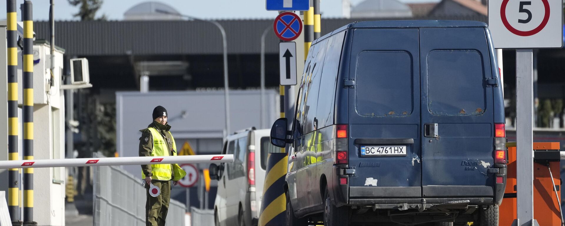 Un guardia fronterizo polaco da instrucciones mientras los conductores esperan para cruzar la frontera de Polonia a Ucrania en Medika, Polonia, el 19 de febrero de 2022 Un guardia fronterizo polaco da instrucciones mientras los conductores esperan para cruzar la frontera de Polonia a Ucrania en Medika, Polonia, el 19 de febrero de 2022 - Sputnik Mundo, 1920, 05.11.2023