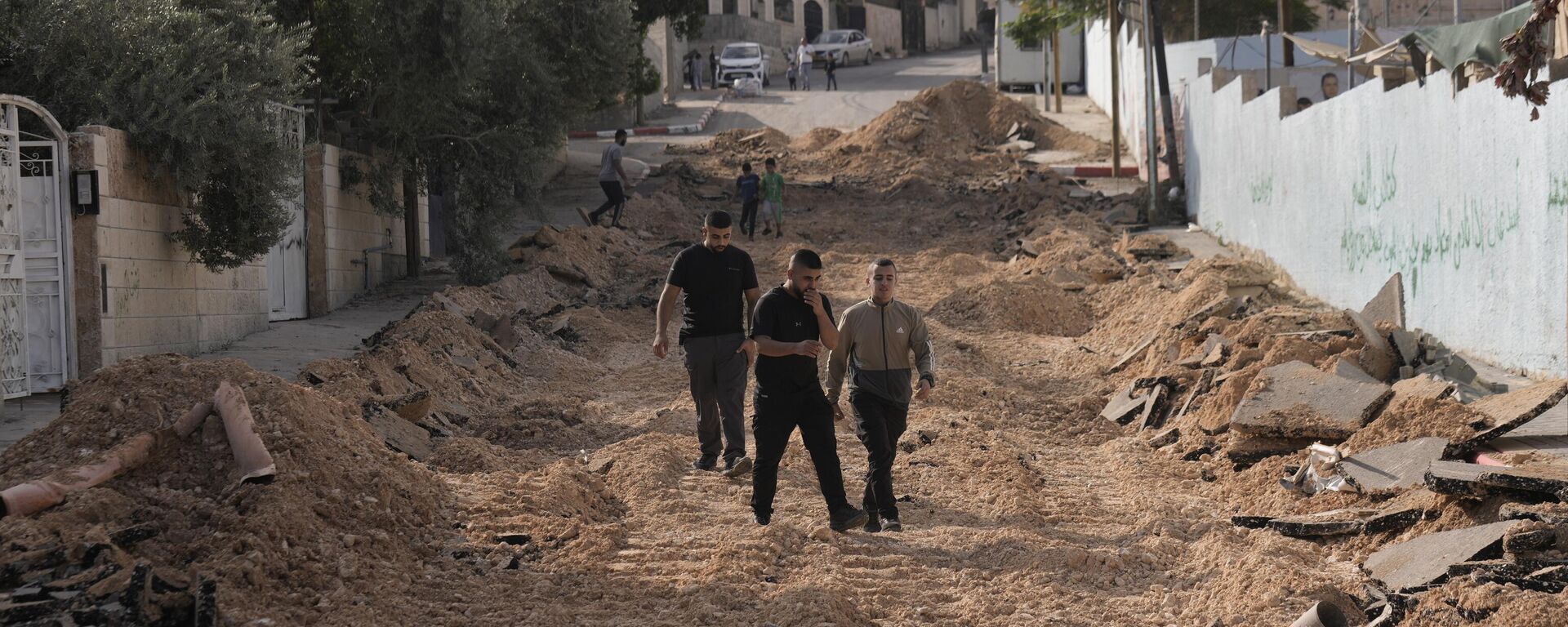 Unos palestinos caminan por una calle destruida en una incursión del Ejército israelí en Yenín, Cisjordania - Sputnik Mundo, 1920, 28.12.2023