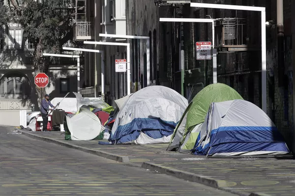 Un hombre junto a tiendas de campaña en una acera de San Francisco. - Sputnik Mundo