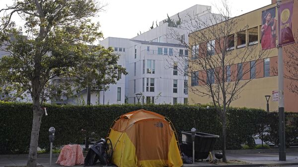 Una tienda de campaña se ve en una acera a la vuelta de la esquina de la Casa de la Ópera con un edificio residencial en el fondo en San Francisco - Sputnik Mundo