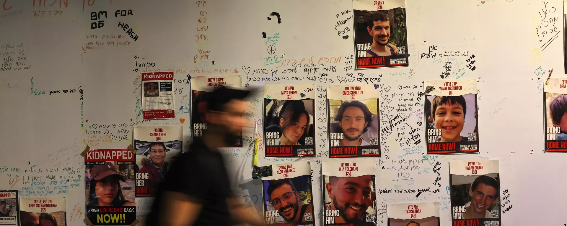 Un hombre camina junto a los retratos de rehenes israelíes colocados en una pared de Tel Aviv el 21 de noviembre de 2023, exigiendo la liberación de los israelíes retenidos como rehenes en Gaza desde el ataque el 7 de octubre Un hombre camina junto a los retratos de rehenes israelíes colocados en una pared de Tel Aviv el 21 de noviembre de 2023, exigiendo la liberación de los israelíes retenidos como rehenes en Gaza desde el ataque el 7 de octubre - Sputnik Mundo, 1920, 22.11.2023