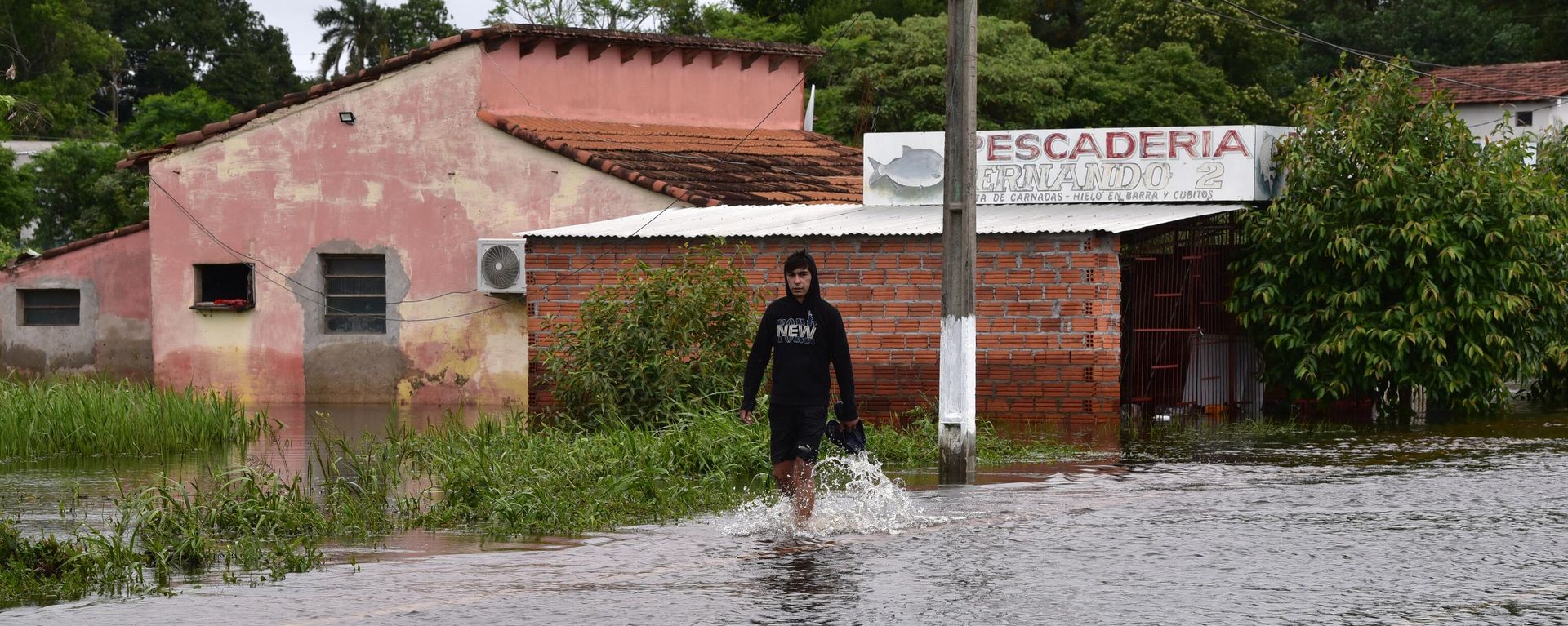 Un hombre vadea el agua en la inundada Ayolas, a 300 km al sur de Asunción (Paraguay), el 3 de noviembre de 2023, tras la crecida del río Paraná por las fuertes lluvias caídas en la región  - Sputnik Mundo, 1920, 22.11.2023