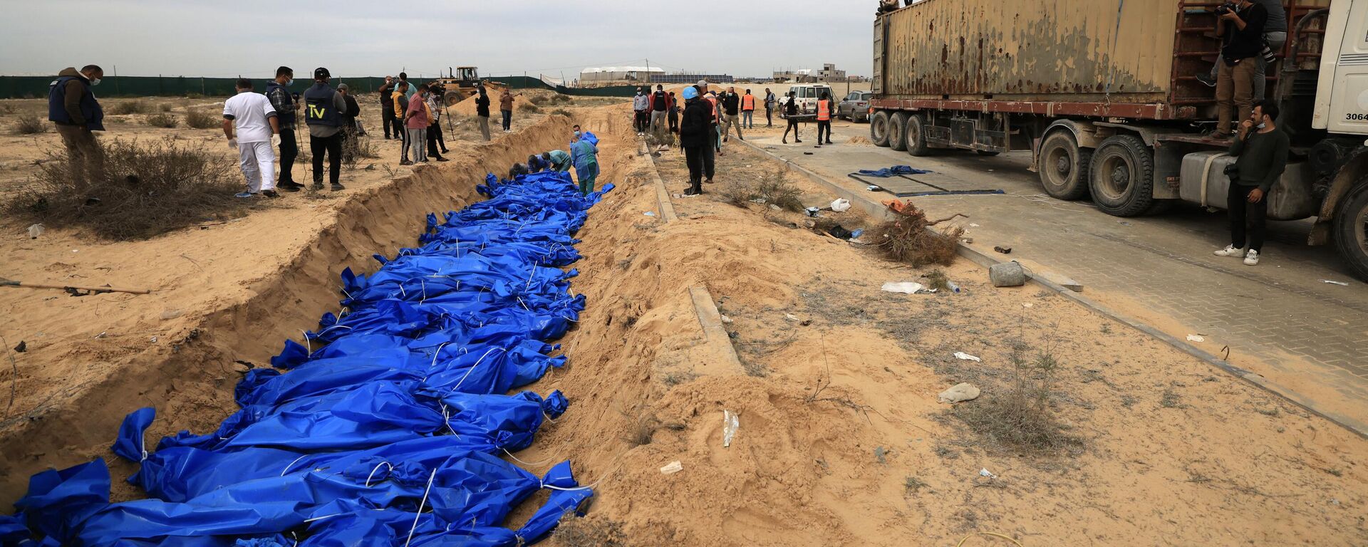 Palestinos entierran cadáveres en una fosa común del cementerio de Jan Yunis, en el sur de la Franja de Gaza, el 22 de noviembre de 2023, en medio de los combates en curso entre Israel y el movimiento palestino Hamás - Sputnik Mundo, 1920, 23.11.2023