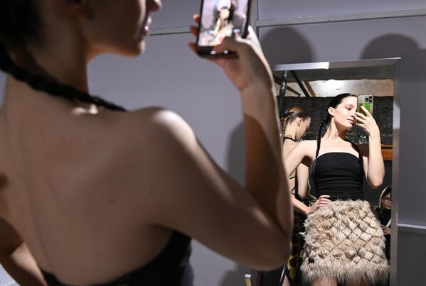 Sus diseños se han hecho famosos por equilibrar la estética clásica con un modernismo radical.En la foto: una modelo antes del desfile de SADAELS. - Sputnik Mundo