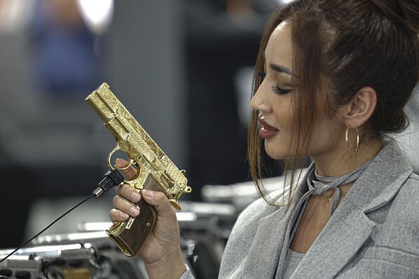 La Egypt Defence Expo (EDEX) 2023, una exposición internacional de la industria militar y de defensa, se inauguró el 4 de diciembre en la capital egipcia de El Cairo.En la foto: una visitante de Kazajistán observa una pistola en la exposición EDEX 2023 en el Centro Internacional de Exposiciones de El Cairo. - Sputnik Mundo