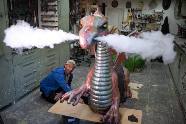 Un hombre posa para una fotografía mientras crea una utilería del dragón en su taller de Blackpool, el Reino Unido. - Sputnik Mundo