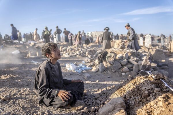 El 7 de octubre, dos fuertes sismos de magnitud 6,3 ocurrieron con media hora de diferencia en la provincia afgana de Herat, causando 2.530 muertos y 9.240 heridos.En la foto: un adolescente afgano ante la tumba de su hermano menor fallecido en el terremoto. - Sputnik Mundo