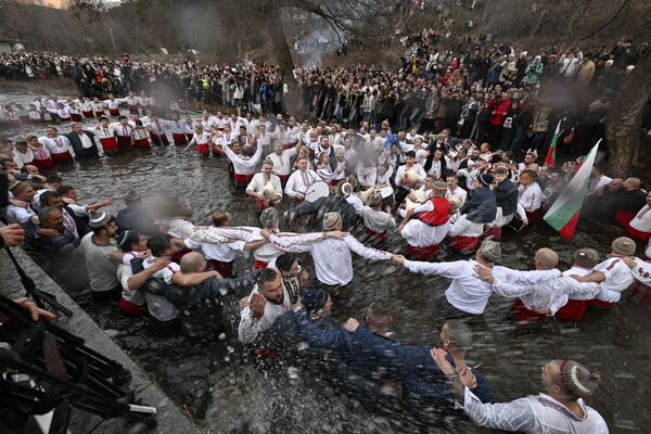 Cristianos ortodoxos bailando la danza tradicional Horo en el río Tundzha en Kalofer, Bulgaria, como parte de las celebraciones de la Epifanía. Cristianos ortodoxos bailando la danza tradicional Horo en el río Tundzha en Kalofer, Bulgaria, como parte de las celebraciones de la Epifanía. - Sputnik Mundo