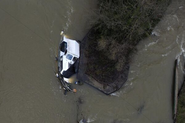 Un barco medio sumergido en el río Támesis durante una inundación en Oxford, Reino Unido. Un barco medio sumergido en el río Támesis durante una inundación en Oxford, Reino Unido. - Sputnik Mundo