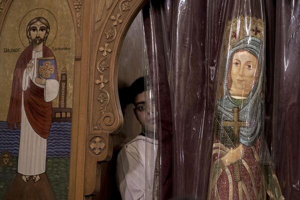 Un fiel de la Iglesia ortodoxa copta mira por una ventana durante un servicio de Nochebuena en la Iglesia de Ava Bishoy y San Karas Anba de Anchorite en El Cairo, Egipto. Un fiel de la Iglesia ortodoxa copta mira por una ventana durante un servicio de Nochebuena en la Iglesia de Ava Bishoy y San Karas Anba de Anchorite en El Cairo, Egipto. - Sputnik Mundo
