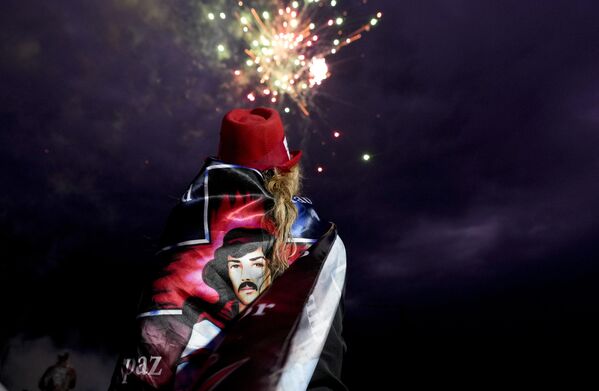 Una mujer observando los fuegos artificiales en el santuario del santo popular argentino Gauchito Gil en Mercedes, provincia de Corrientes. Una mujer observando los fuegos artificiales en el santuario del santo popular argentino Gauchito Gil en Mercedes, provincia de Corrientes. - Sputnik Mundo