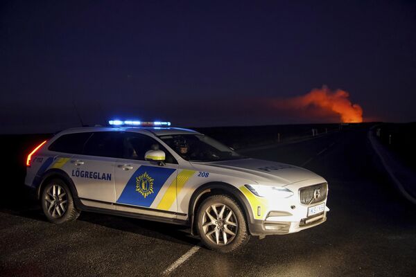 La actividad sísmica y volcánica de Islandia se debe a su ubicación entre las placas tectónicas euroasiática y norteamericana, que se mueven en direcciones opuestas.En la foto: un automóvil de la policía bloquea la carretera a Grindavik después de que el volcán entrara en erupción. - Sputnik Mundo