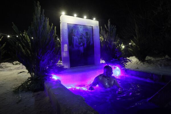 Lo más importante para los cristianos ortodoxos en la Epifanía, es asistir a un oficio religioso, confesarse, comulgar y tomar agua bendita. En la foto: baño bautismal en un estanque de Ekaterimburgo. - Sputnik Mundo